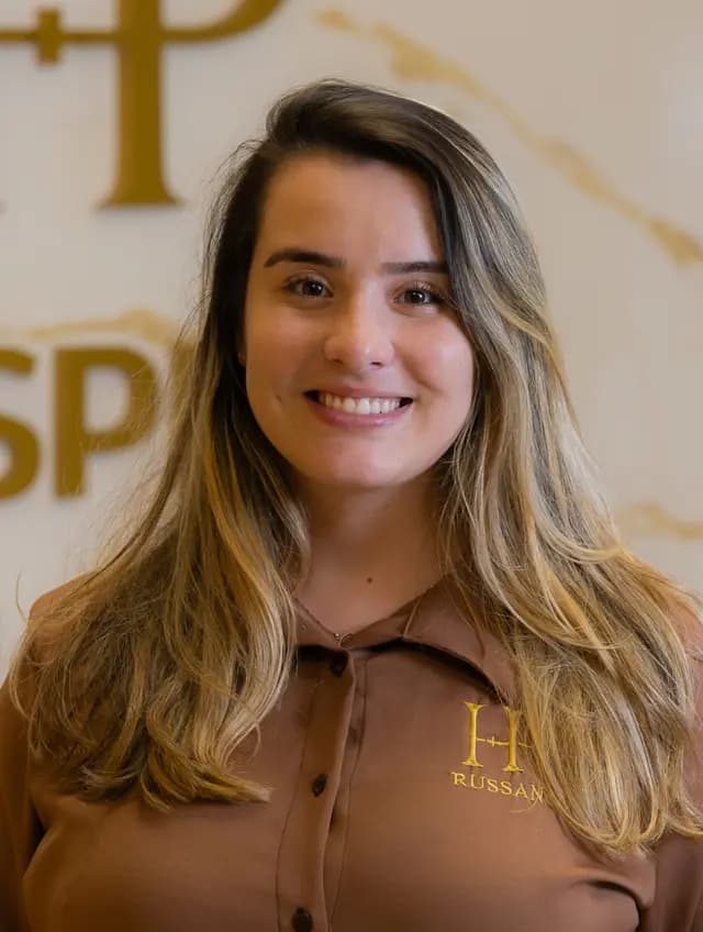 Amanda Rangel, de camisa marrom do uniforme, sorrindo