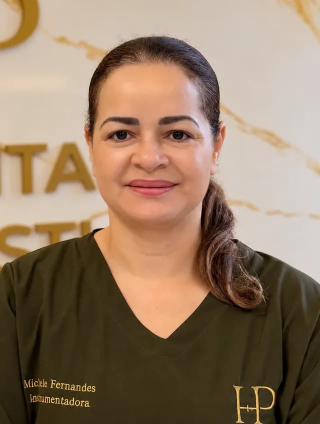 Michele Fernandes, de cabelo preso de lado e uniforme verde-oliva, sorrindo