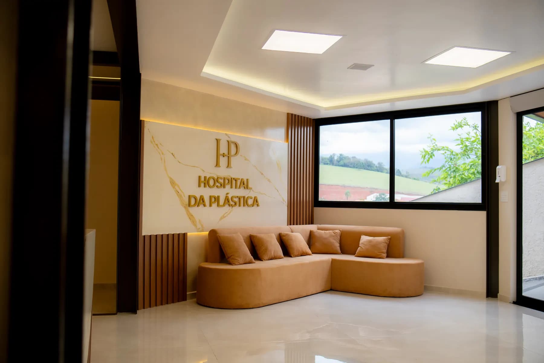 Sala de espera com sofá bege e o letreiro do hospital